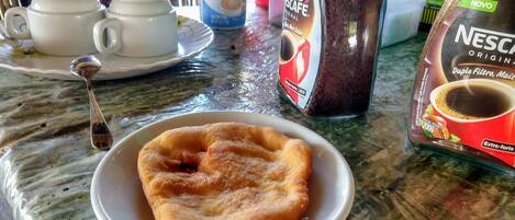 A breakfast setting with a plate of pastries, a coffee maker, and a Nescafé coffee pod.