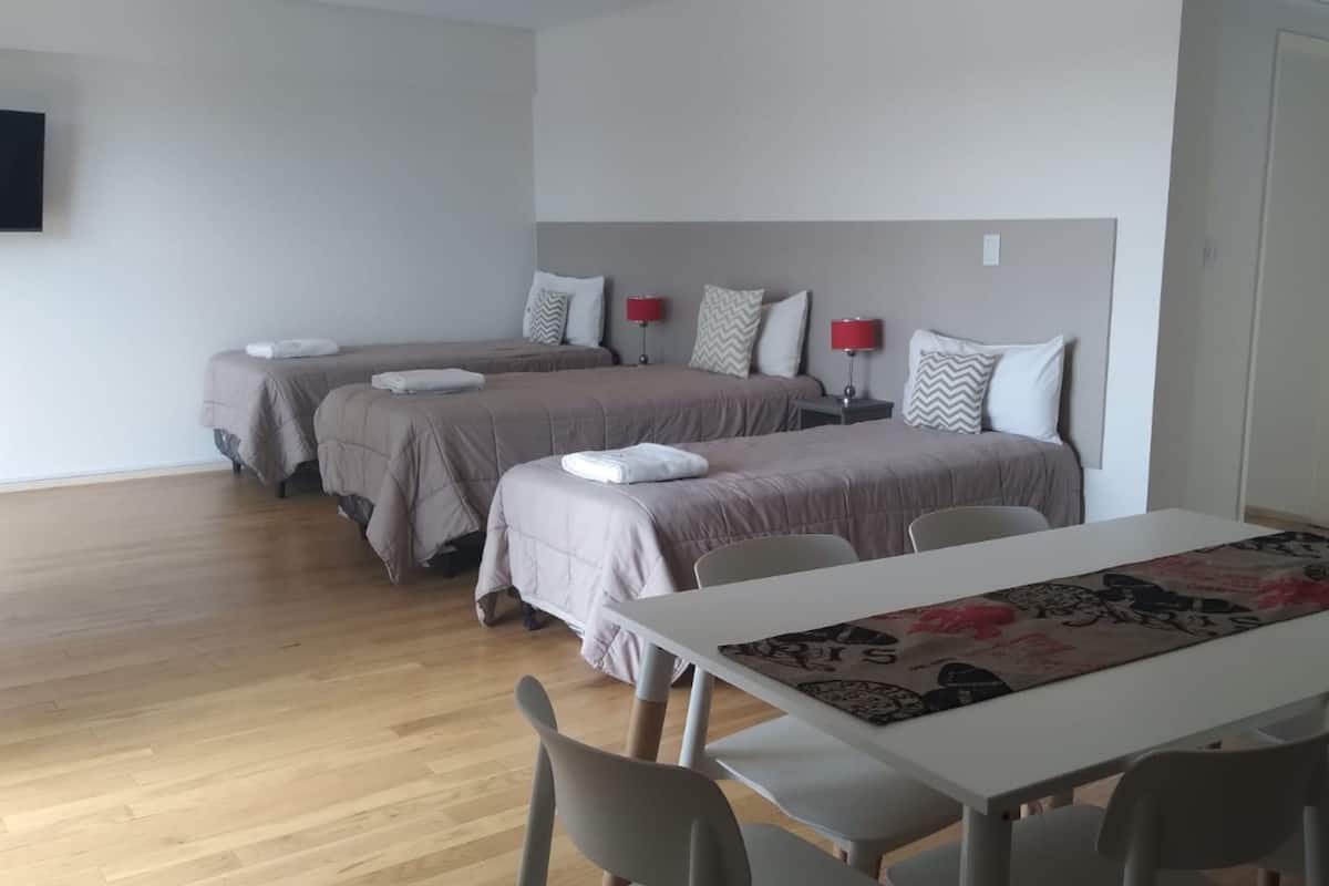Une chambre d’hôtel avec deux lits, une table et des chaises.
