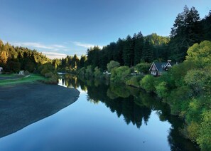 A serene riverside scene with a hotel and a small building by the water. - Highland Dell Lodge (Monte Rio)