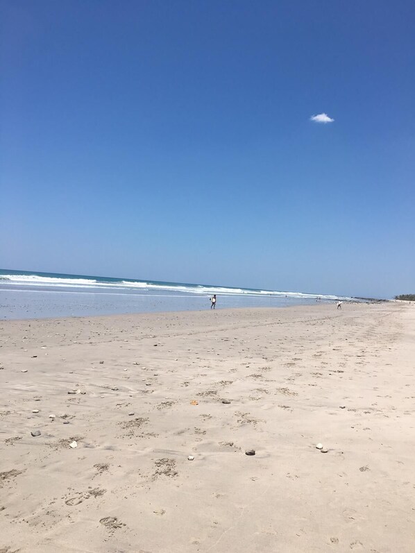 Na praia, espreguiçadeiras, toalhas de praia 