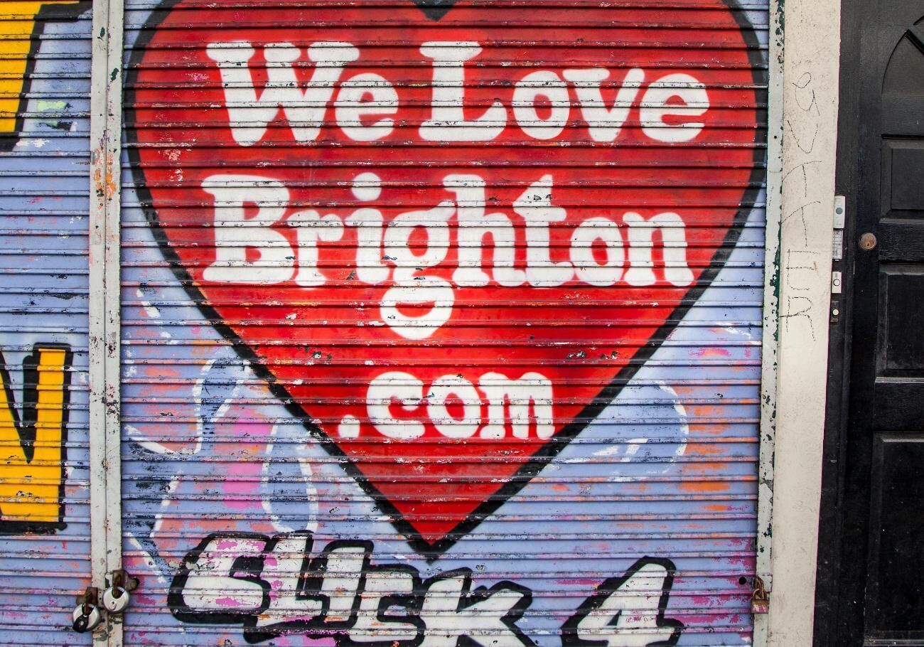 Um sinal em forma de coração vermelho com a inscrição 'We Love Brighton.com'.
