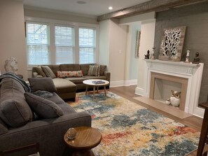 Cozy living room with a large sectional sofa, round coffee table, and fireplace.