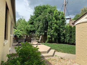 Enjoy a peaceful retreat in this serene backyard oasis with a patio, garden, and lawn.