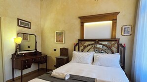 A hotel room with a wooden ceiling, a bed with white linens, a nightstand with a lamp, and a mirror. - Garibaldi Suite - Turin's downtown - Turin center (Torino)