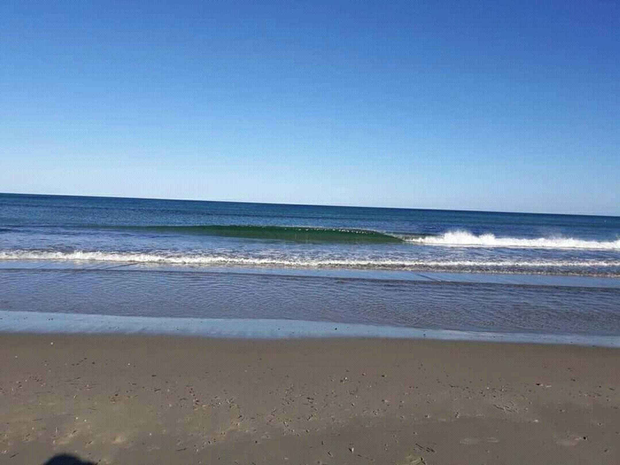 Una spiaggia con onde e cielo sereno.