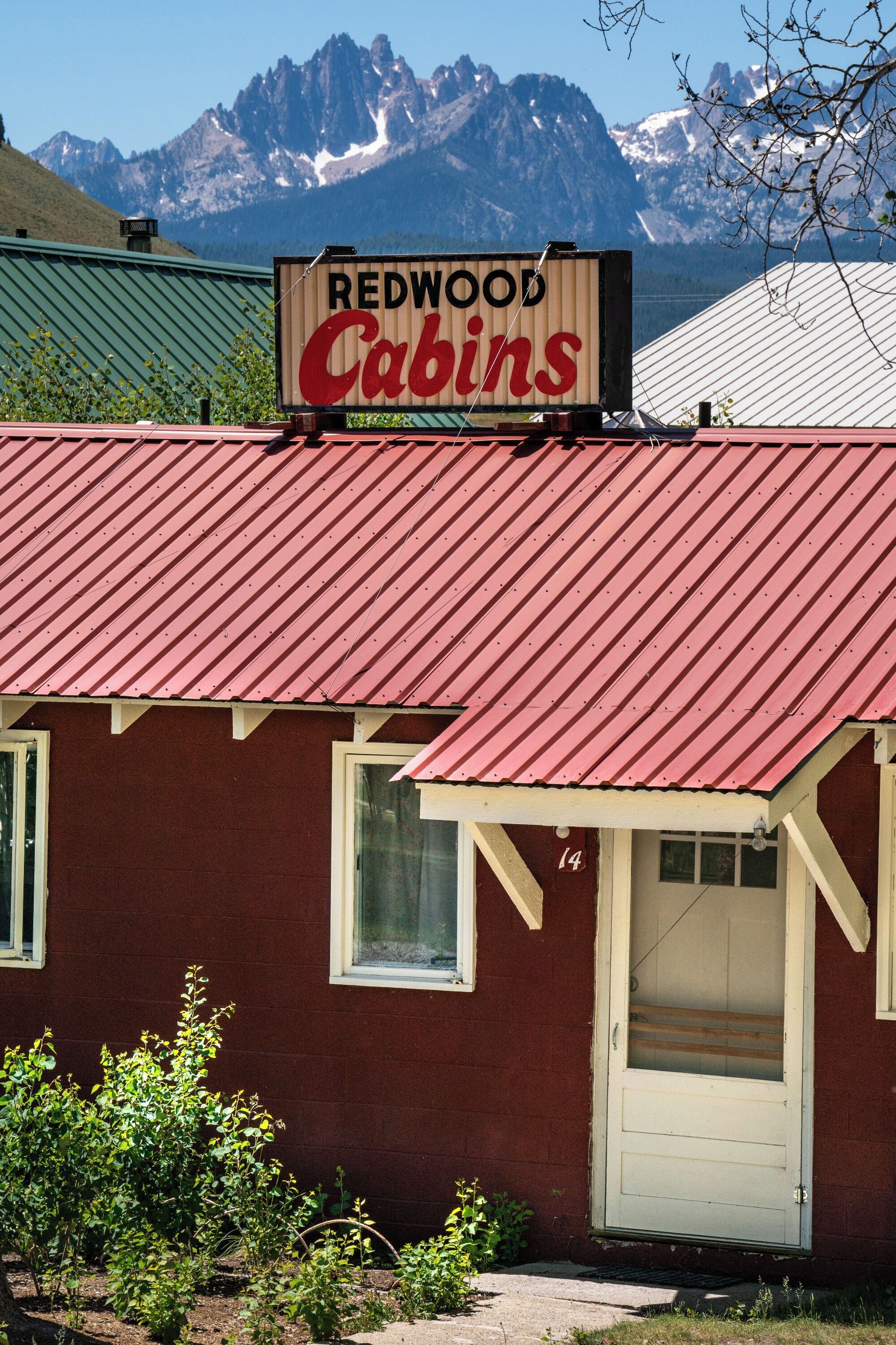 Un bâtiment de Redwood Cabins avec un toit rouge et une enseigne au-dessus de l’entrée.