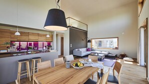 A modern kitchen with wooden cabinets, a central island, and pendant lighting.