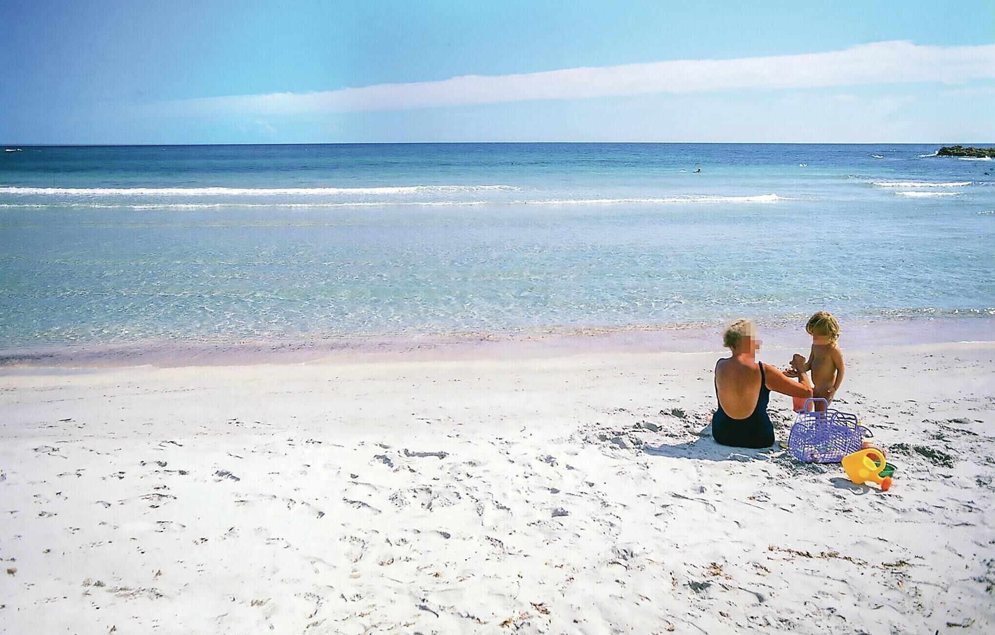 Une plage offrant une vue dégagée sur l’océan et bordée d’un rivage sablonneux.