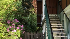 Eine Treppe mit grünen Geländern, die zu einer Holztür führt.