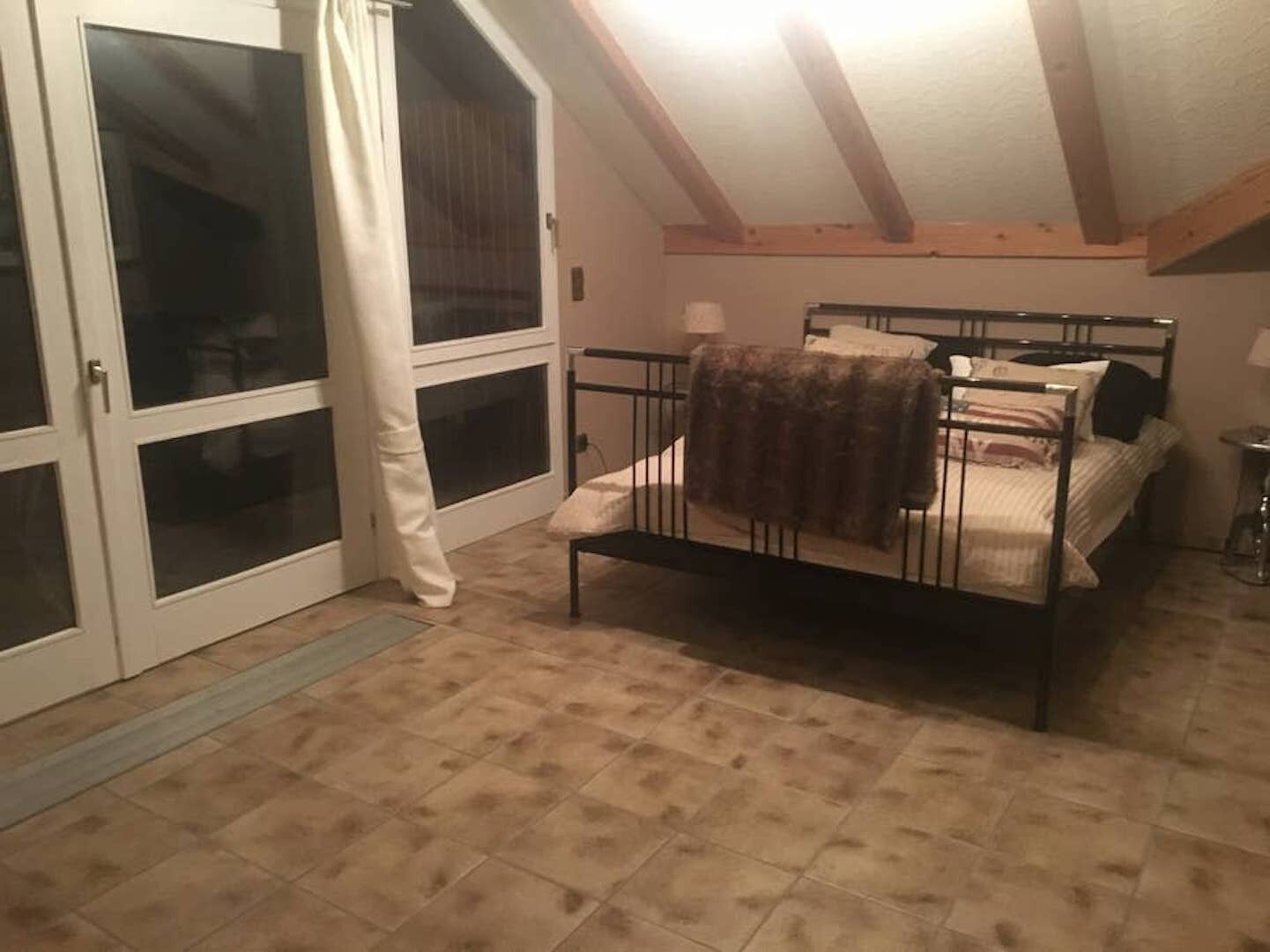 Une chambre à coucher avec un lit, une fenêtre et une porte-fenêtre coulissante.