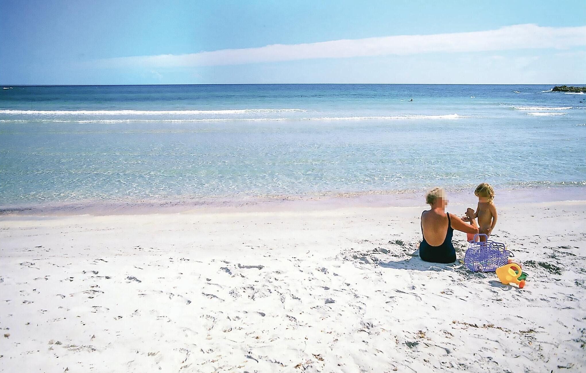 A beach with a clear sky and calm sea.