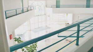A multi-level interior with glass railings and a central open space.