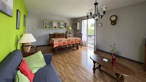 Ein Wohnzimmer mit einer Couch, einem Esstisch und einer Chandelüster.