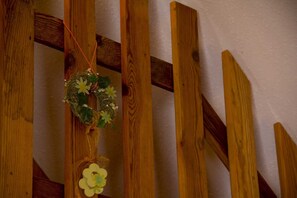 A wooden staircase with a decorative wreath hanging on the side.