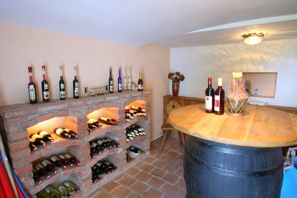 Une cave à vin dotée de plusieurs étagères à bouteilles et d’un espace bar.