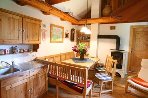 Una cocina de madera con una mesa de comedor, bancos y una chimenea.