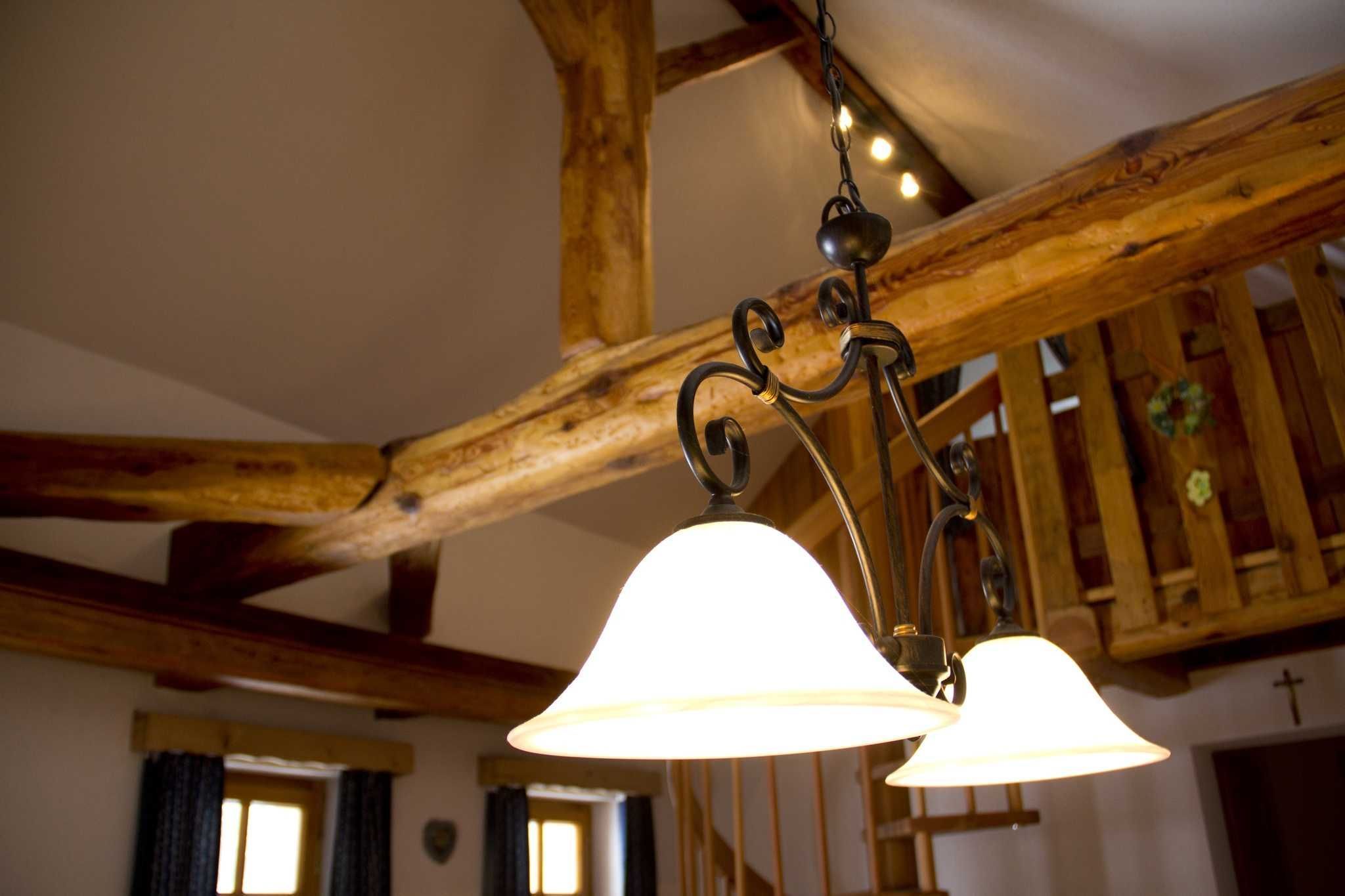 A wooden ceiling with exposed beams and a hanging light fixture.
