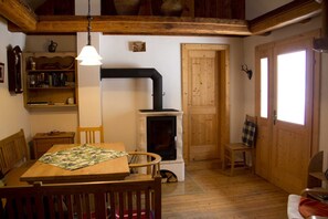 A cozy room with a fireplace, wooden furniture, a bookshelf, and a window.