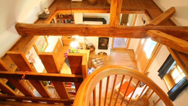 Un interior de madera con una escalera, chimenea y comedor.