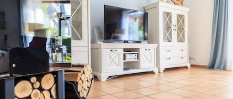 A living room with a television, white cabinets, and a fireplace.