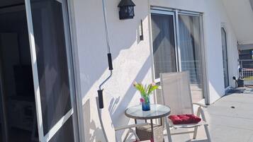 Ein Balkon mit Tisch, Stühlen und einem Fenster.