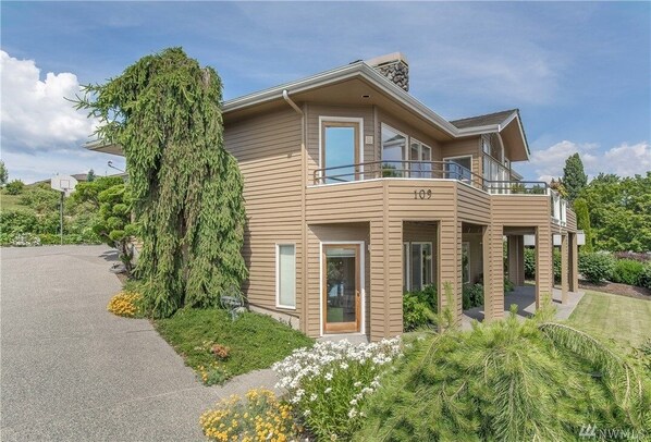 A two-story house with a balcony, a driveway, and a well-maintained garden. - Shore View Home Retreat (Manson)