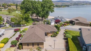 Un quartiere residenziale con case, un vialetto e un lago sullo sfondo.