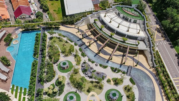 An aerial view of a hotel with a central swimming pool, landscaped gardens, and a circular building structure. - Green Haven by Tove Global (Masai)
