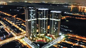 A high-rise hotel with multiple floors, a central courtyard, and surrounding parking. - Green Haven by Tove Global (Masai)