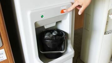 A water dispenser with a push button and a green indicator light.