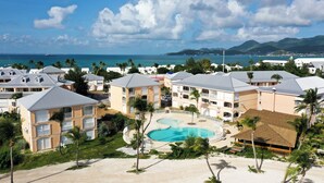 A resort with multiple buildings, a swimming pool, and a beach. - Lagoon front Magnificent Studio completely renovated with panoramic lagoon view (Saint-Martin)