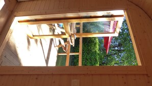 A wooden interior with a skylight, wooden beams, and a red flag.