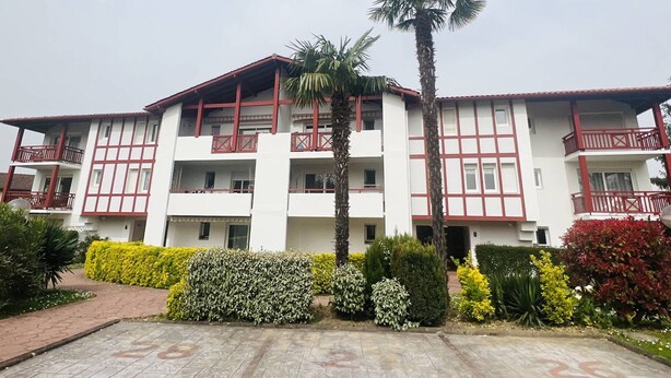 A multi-story building with balconies, a central palm tree, and well-maintained landscaping. - Studio in Cambo-les-Bains, balcony, parking, sleeps 2 (Cambo-les-Bains)