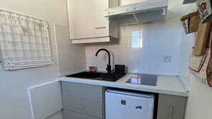 A compact kitchen with a sink, a small refrigerator, and a drying rack. - Studio in Cambo-les-Bains, balcony, parking, sleeps 2 (Cambo-les-Bains)