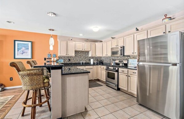 Enjoy cooking in this well-equipped kitchen with stainless steel appliances, a central island, and a dining area.