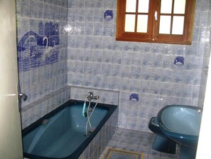 A bathroom with a bathtub, a sink, and decorative tiles. - House in Vannes (Gulf of Morbihan) (Séné)