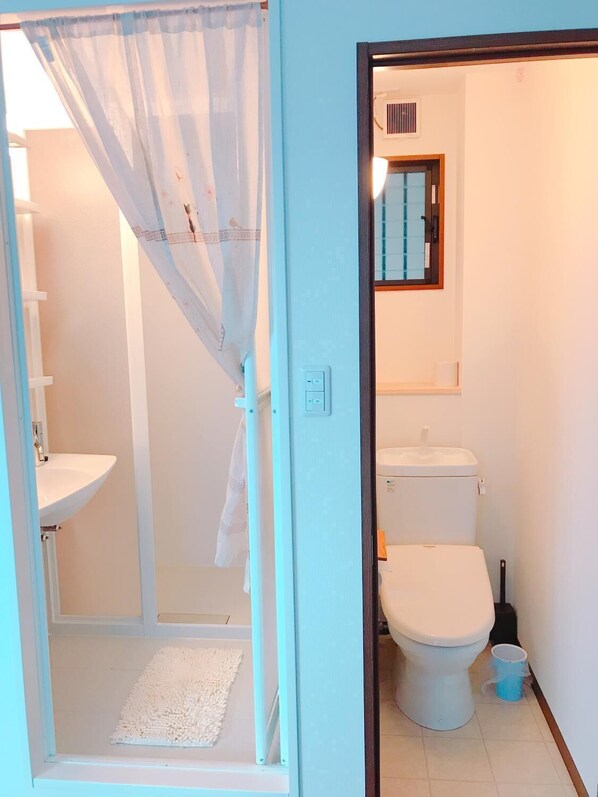 A bathroom with a shower, toilet, and sink. - Osaka Sinsei Guest House Daikokukan (Osaka)