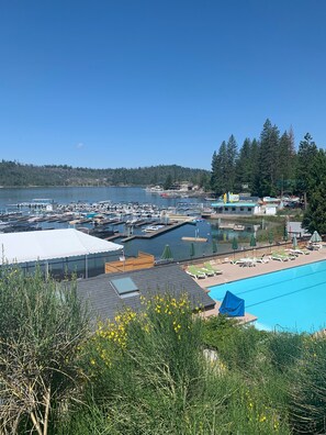 A marina with boats docked, a swimming pool, and a view of a forested hill. - Beautiful Family Cabin - Short drive to Bass Lake Beaches - 2100 sq ft (Bass Lake)
