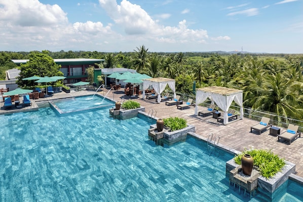 Alberca al aire libre, sombrillas en la alberca y camastros 