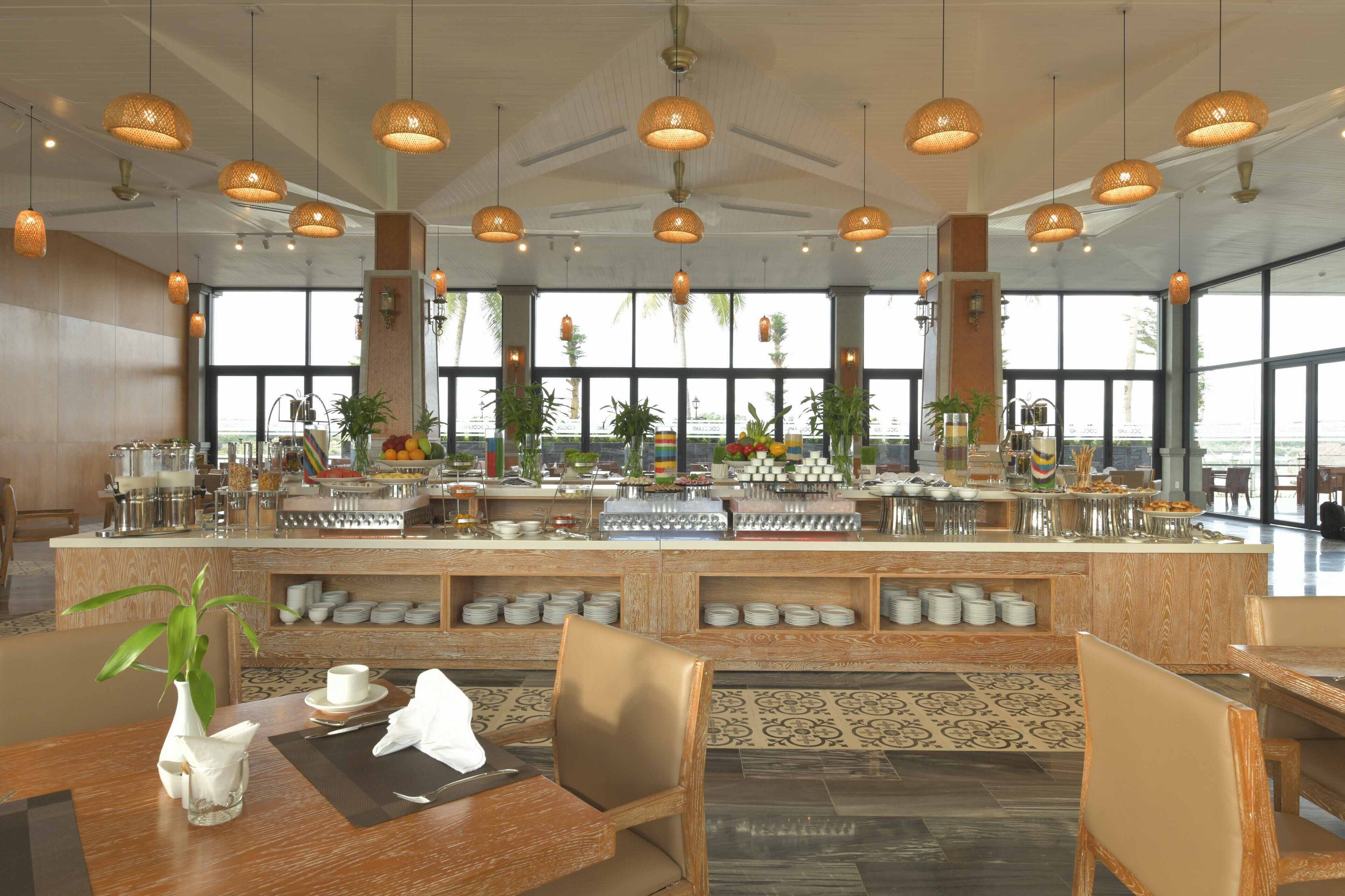 Un restaurante con mesas de buffet, muebles de madera y grandes ventanales con vistas.