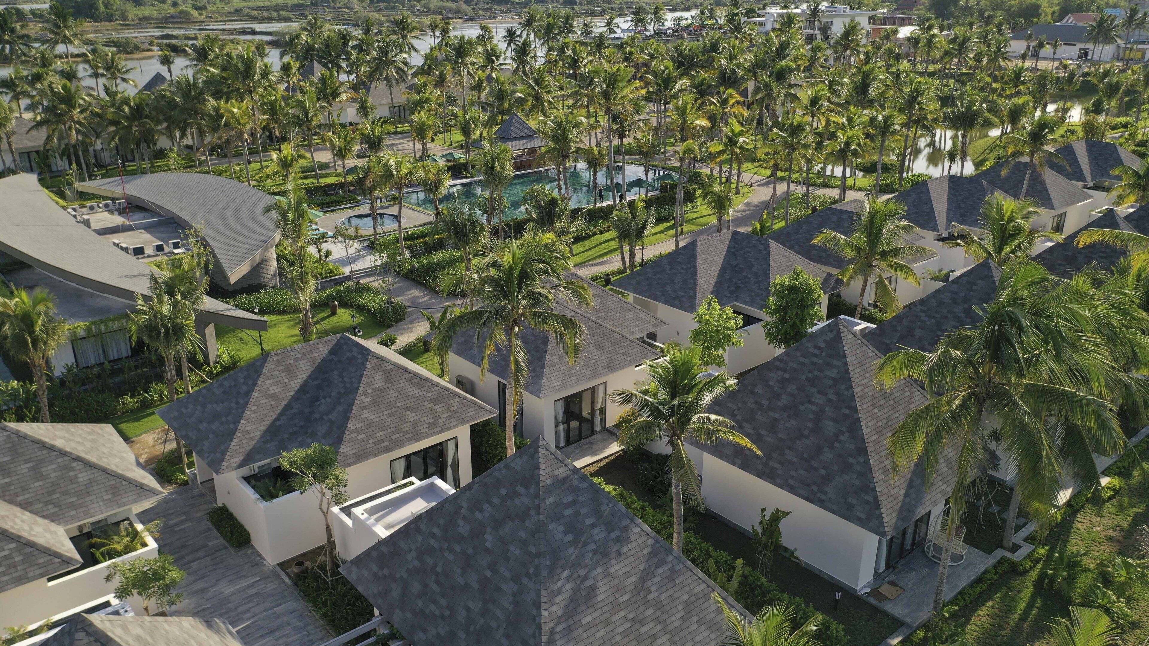 Un quartier résidentiel avec des maisons modernes, une piscine et des palmiers.