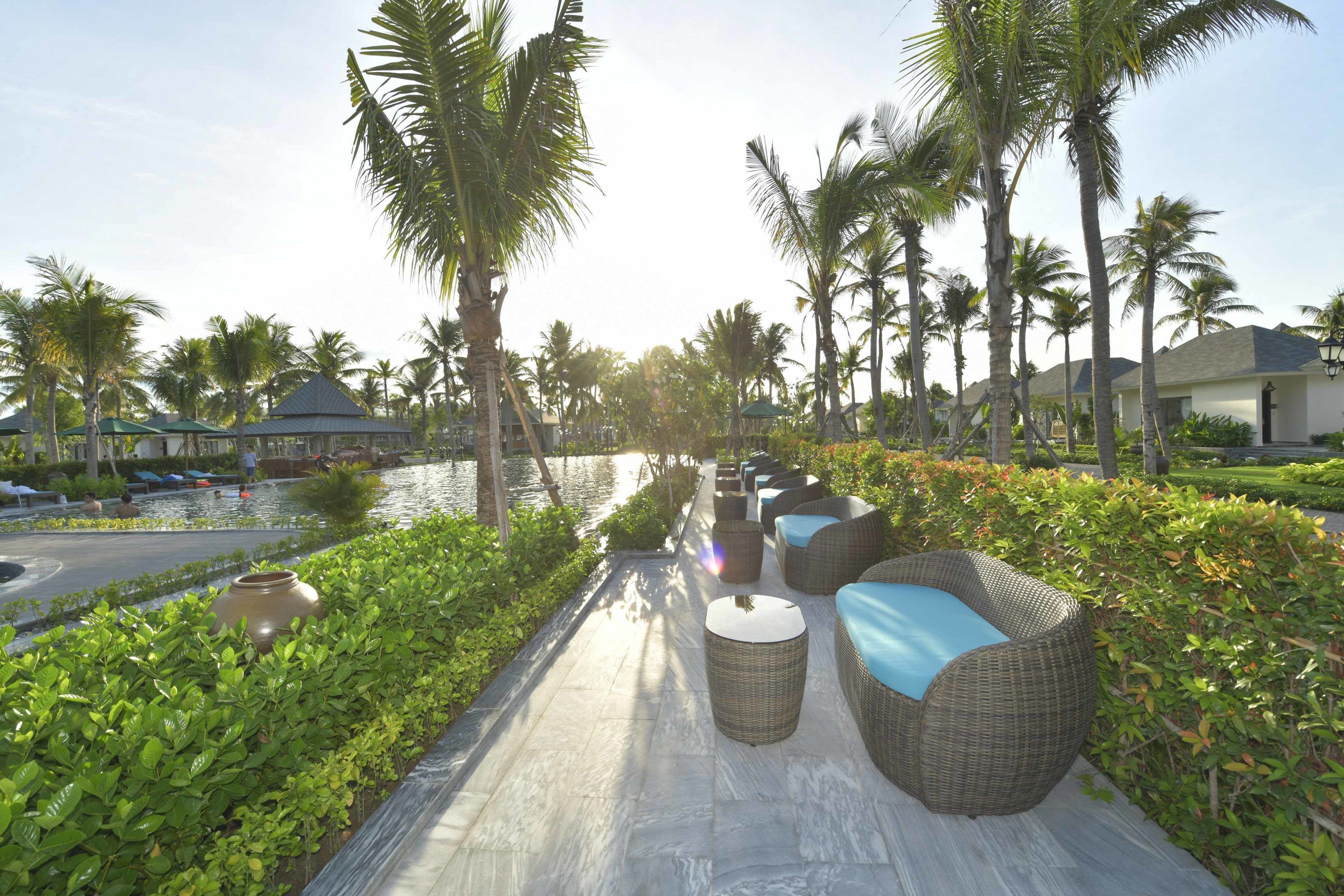 Una piscina al aire libre, sombrillas, sillones reclinables de piscina
