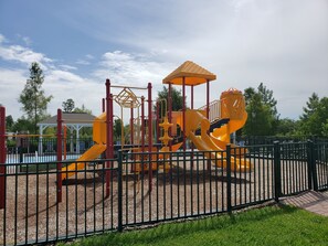 Kids can play on the slide and climbing elements in this enclosed playground.