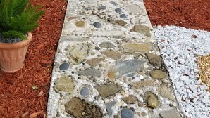 A stone pathway leading to a house with a black fence and potted plants on either side. -  Family & Pet Friendly (*additional pet fee will apply), Charming Orlando Home! (Orlando)