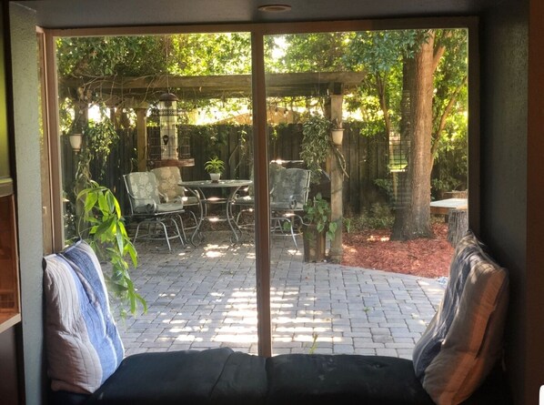 A patio with a table and chairs, surrounded by plants and a wooden pergola. -  Family & Pet Friendly (*additional pet fee will apply), Charming Orlando Home! (Orlando)