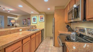 A modern kitchen with granite countertops, stainless steel appliances, wooden cabinets, and recessed ceiling lights. - Last Minute Holiday Rates! Panoramic views from Balcony (Keystone)