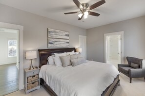 A bedroom with a large bed, a ceiling fan, a nightstand with a lamp, and a chair. - Perfect Lake Hartwell Getaway - Gorgeous Lake Views! (Seneca)
