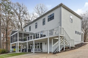 A two-story house with a covered porch and a staircase leading to a second-floor balcony. - Perfect Lake Hartwell Getaway - Gorgeous Lake Views! (Seneca)