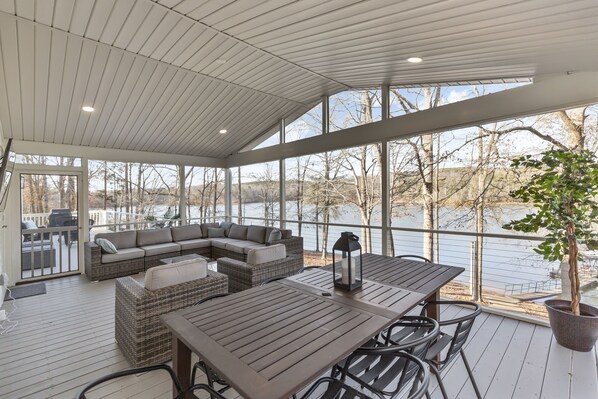 A covered outdoor deck with a dining table, chairs, and a sofa. - Perfect Lake Hartwell Getaway - Gorgeous Lake Views! (Seneca)