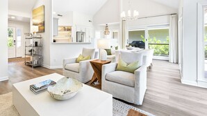 A spacious living room with a white sofa set, a coffee table, and a chandelier. - 21 Shell Ring:  BESTNEST by Beverly Serral Vacation Rentals (Hilton Head Island)